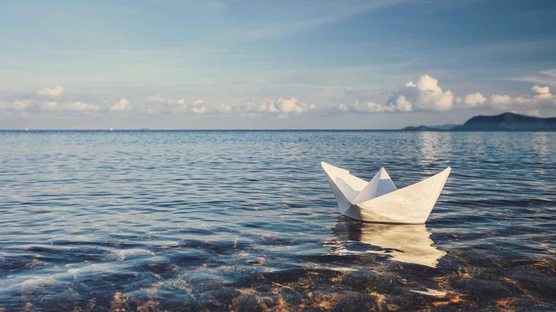 origami boat sailing on the water