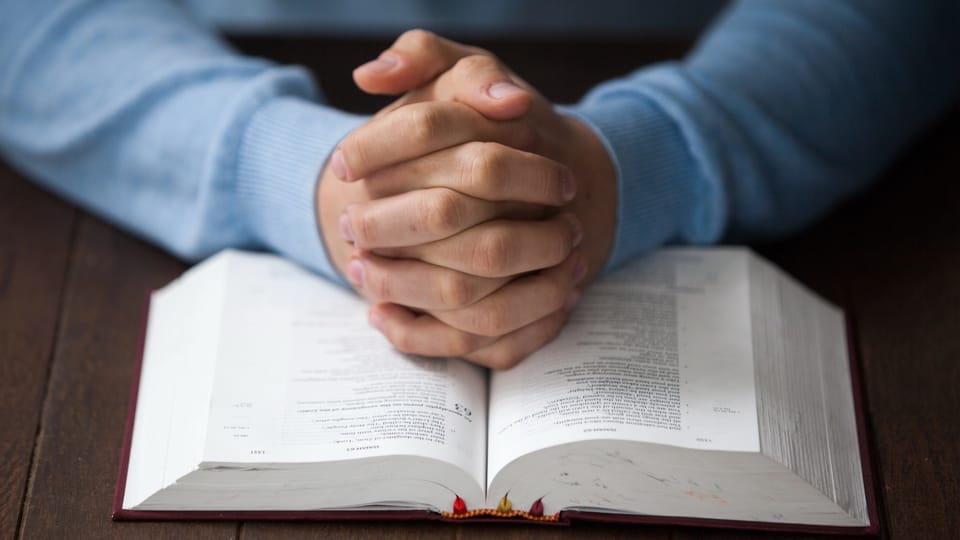 man praying with Bible
